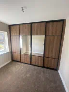 4 door brown casella panels with a 1/4 - 1/2 - 1/4 splits with the middle two doors having mirror in brushed black frames, fitted in Bowburn